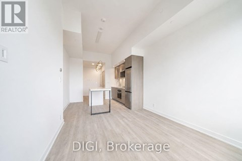 A room with a kitchenette and a refrigerator in it.