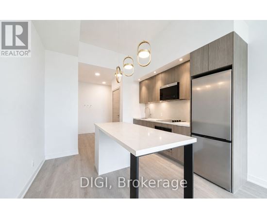 A modern kitchen with a white countertop and stainless steel appliances.
