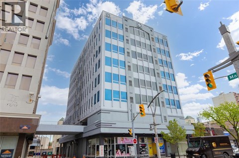 A street view with a building in the background and a traffic light on the right.
