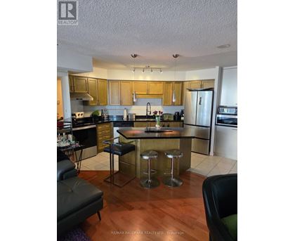 A kitchen with a black bar stool in the middle of the island.