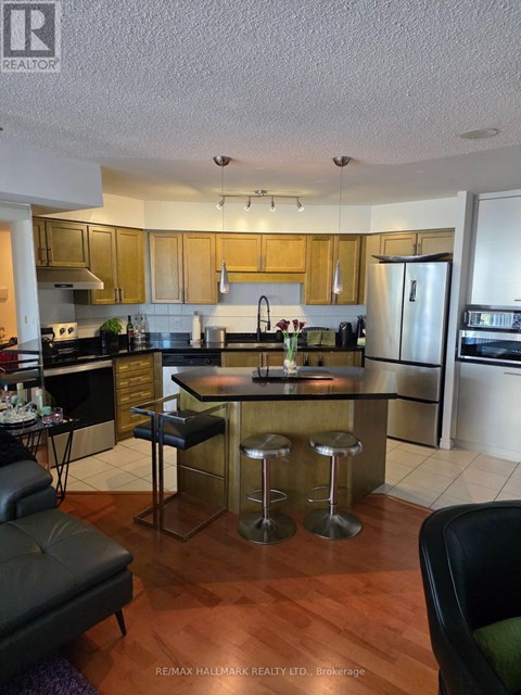 A kitchen with a black bar stool in the middle of the island.