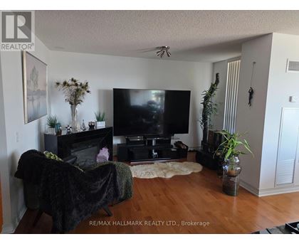 A living room with a black couch and a flat screen TV.