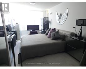 A bedroom with a large bed and a wall hanging of a bird.