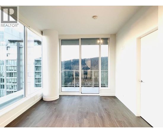 A room with a large window and a wooden floor.