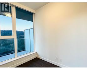 A room with a large window and a view of trees outside.