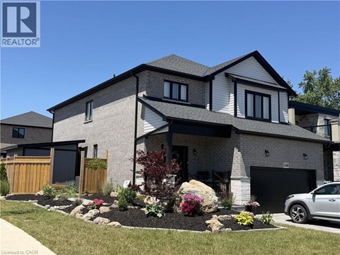 A modern house with a grey and white exterior and a landscaped front yard.