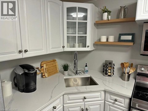 A kitchen with white cabinets and a marble countertop.