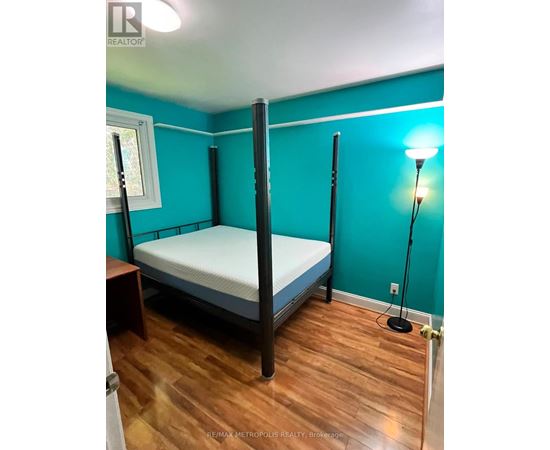 A bedroom with a four poster bed and a window.