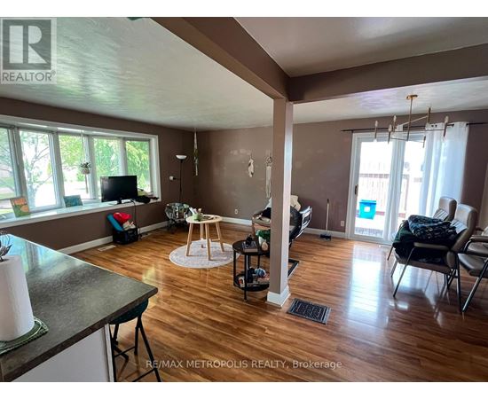 A living room with a television, a dining table, and chairs.