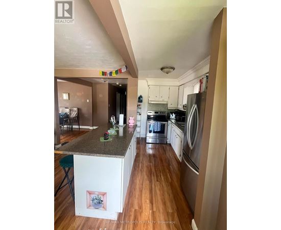 A kitchen with a white island and stainless steel appliances.