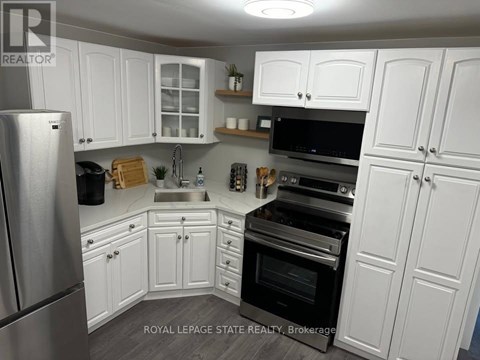 A kitchen with white cabinets and stainless steel appliances.