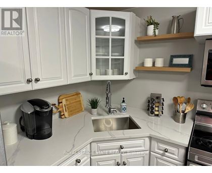 A kitchen with white cabinets and a marble countertop.