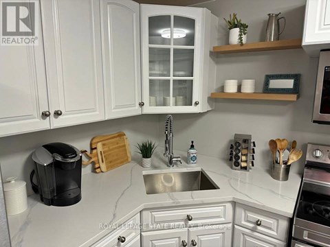 A kitchen with white cabinets and a marble countertop.