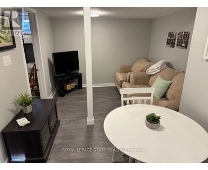 A living room with a white couch and a television.