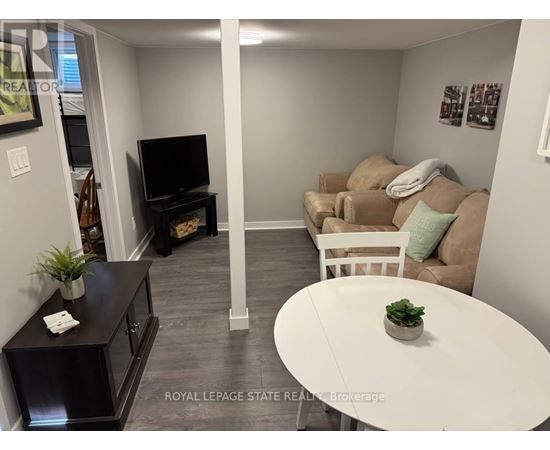 A living room with a white couch and a television.