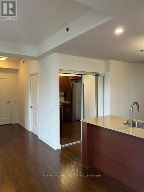 A kitchen area with a sink and a refrigerator.