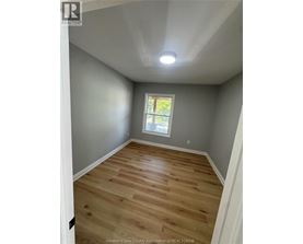 A room with wooden flooring and a window.