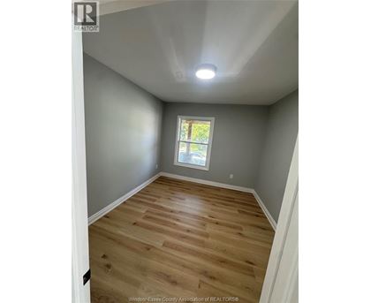 A room with wooden flooring and a window.