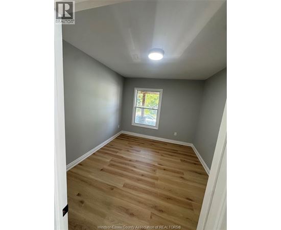 A room with wooden flooring and a window.