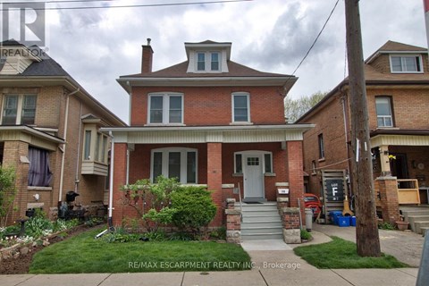 A house with a red brick facade and a grey door.