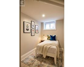 A bedroom with a bed, pillow, blanket and pictures on the wall.