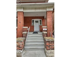A white door is on the front of a brick building.