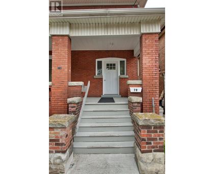 A white door is on the front of a brick building.