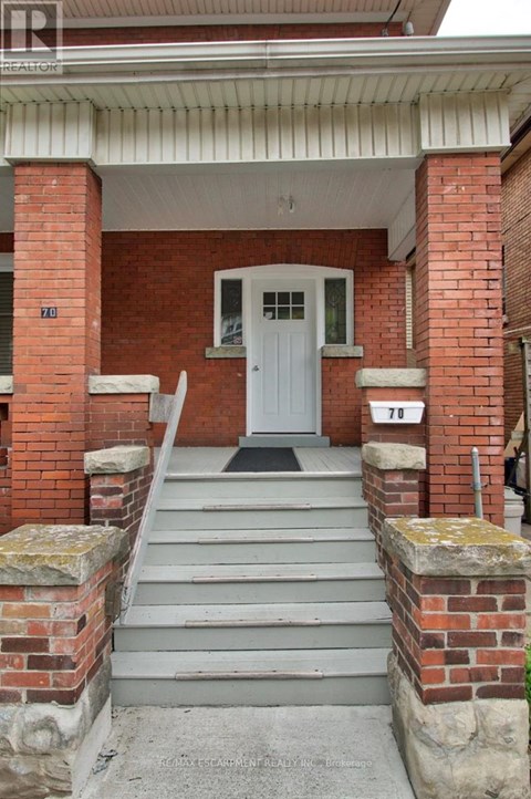 A white door is on the front of a brick building.
