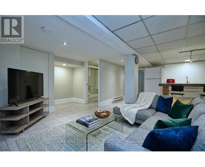 A living room with a grey couch and a glass coffee table.