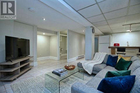 A living room with a grey couch and a glass coffee table.
