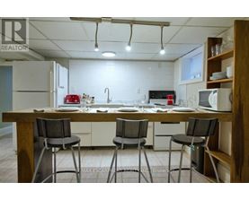 A kitchen with a table and chairs in front of a fridge and microwave.
