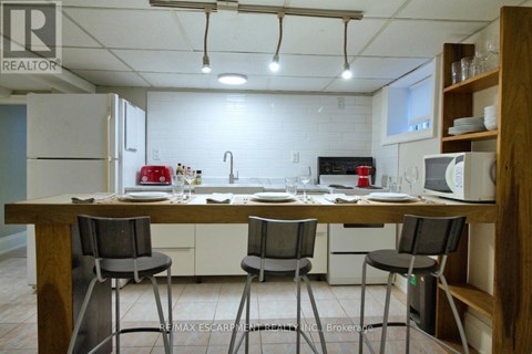 A kitchen with a table and chairs in front of a fridge and microwave.