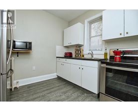 A kitchen with white cabinets and a microwave on the wall.