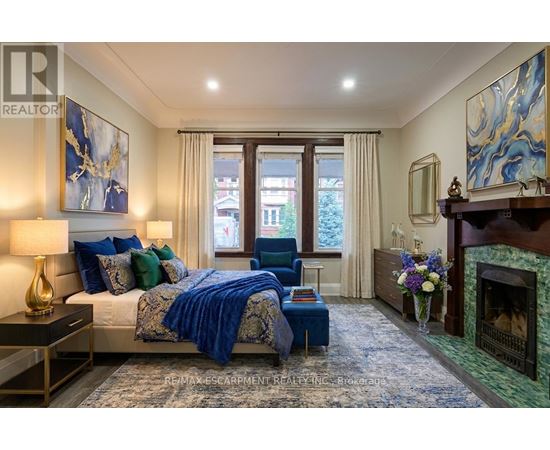 A bedroom with a large bed and a fireplace.