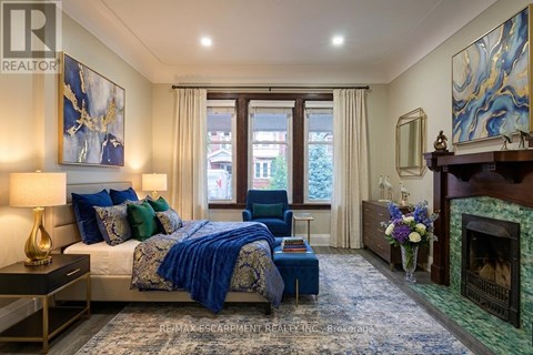 A bedroom with a large bed and a fireplace.