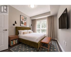 A bedroom with a bed, nightstand, and window.