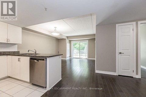 A kitchen with white cabinets and a black granite countertop.