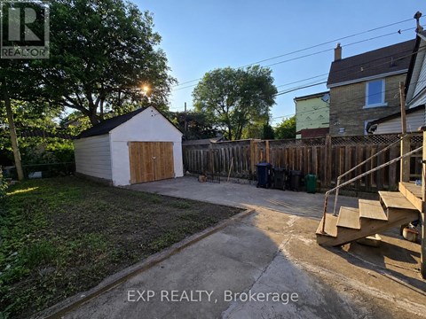 A backyard with a shed, a fence, and a deck.