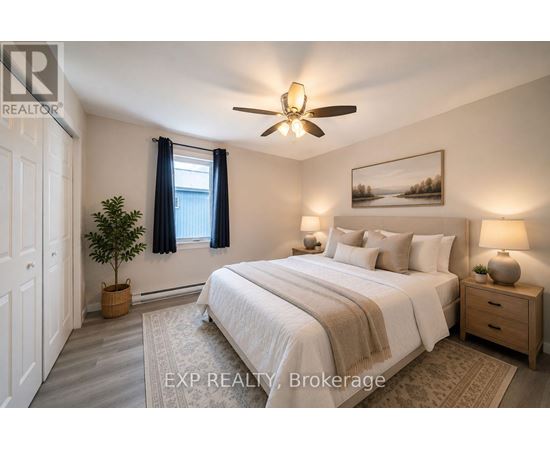 A bedroom with a bed, nightstand, and a ceiling fan.
