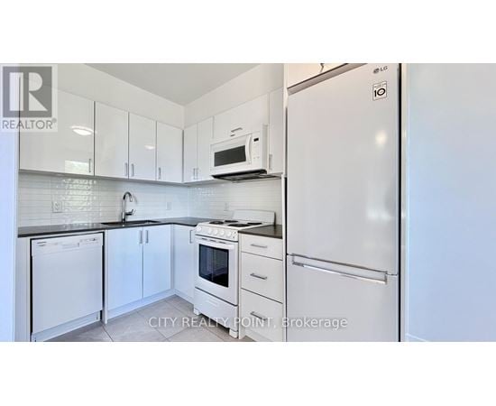 A kitchen with white appliances and cabinets.