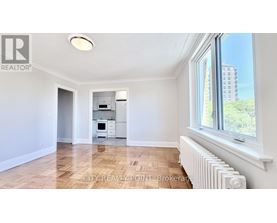 A spacious room with a window and a radiator on the floor.