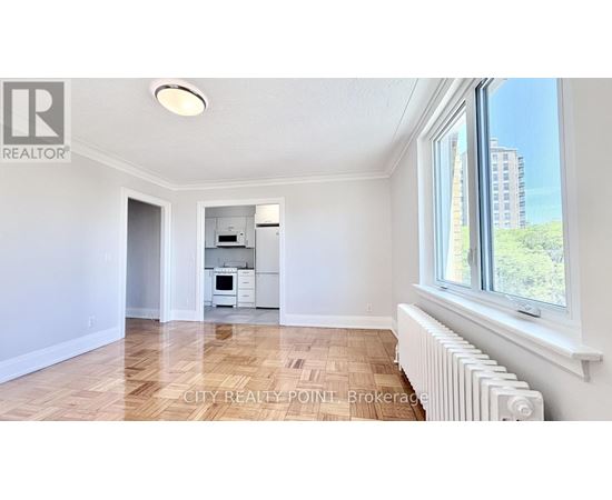 A spacious room with a window and a radiator on the floor.