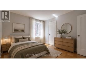 A well-lit bedroom with a large bed, a nightstand, and a dresser.