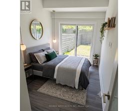 A bedroom with a bed, a mirror, and a small potted plant.