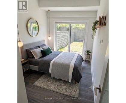 A bedroom with a bed, a mirror, and a small potted plant.