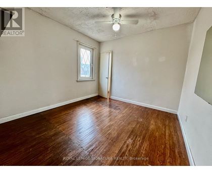 A room with wooden flooring and a window.