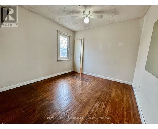 A room with wooden flooring and a window.
