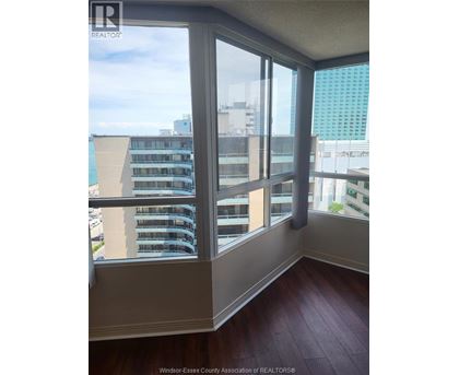 A room with a view of a cityscape through large windows.