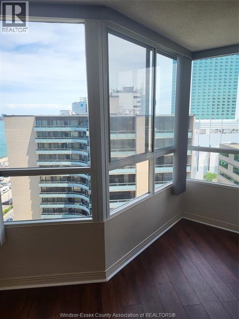 A room with a view of a cityscape through large windows.