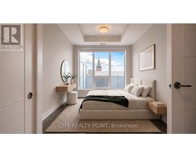 A bedroom with a bed, nightstand, and a window overlooking a cityscape.